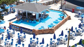 A pool area with a bar and lounge chairs. - Cape Cod Family Resort and Parks (West Yarmouth)