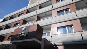 Ein mehrstöckiges Hotel mit modernem Design, das ein gut sichtbares Logo an der Fassade zeigt.