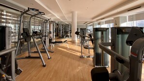 A gym with various exercise machines, large windows, and a wooden floor. - ZTE Hotel Shanghai (Shanghai)