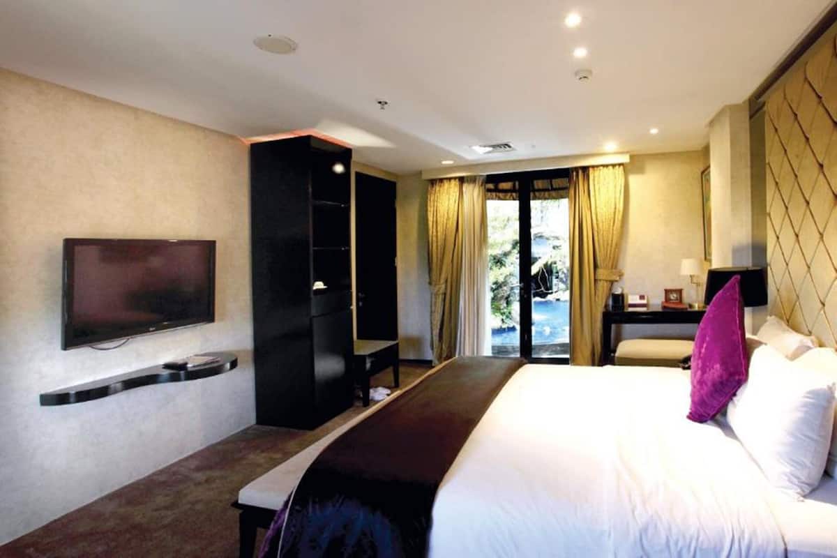 Une chambre d’hôtel équipée d’un lit, d’une télévision, d’une armoire, d’un bureau et offrant une vue sur l’extérieur.