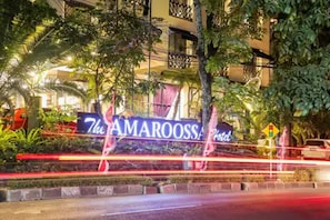 The Amarossa Hotel sign with a tropical garden backdrop.