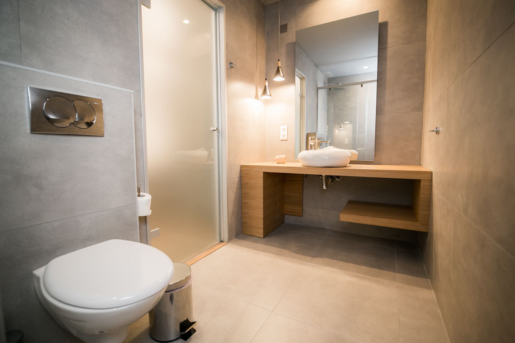 Une salle de bain moderne équipée de toilettes, d’un lavabo et d’une douche.