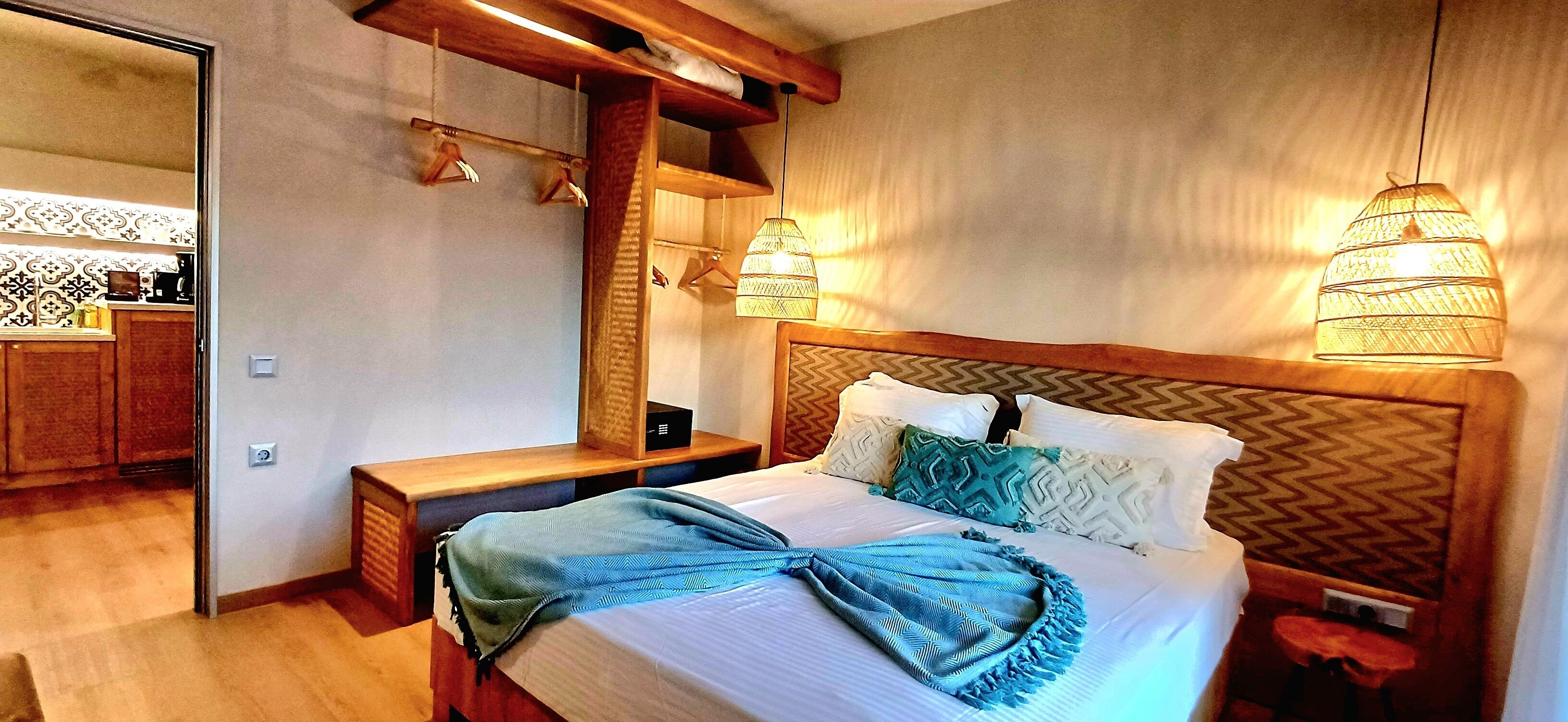 Ein Schlafzimmer mit Bett, Nachttischen, einem Spiegel und einer Hängelampe.