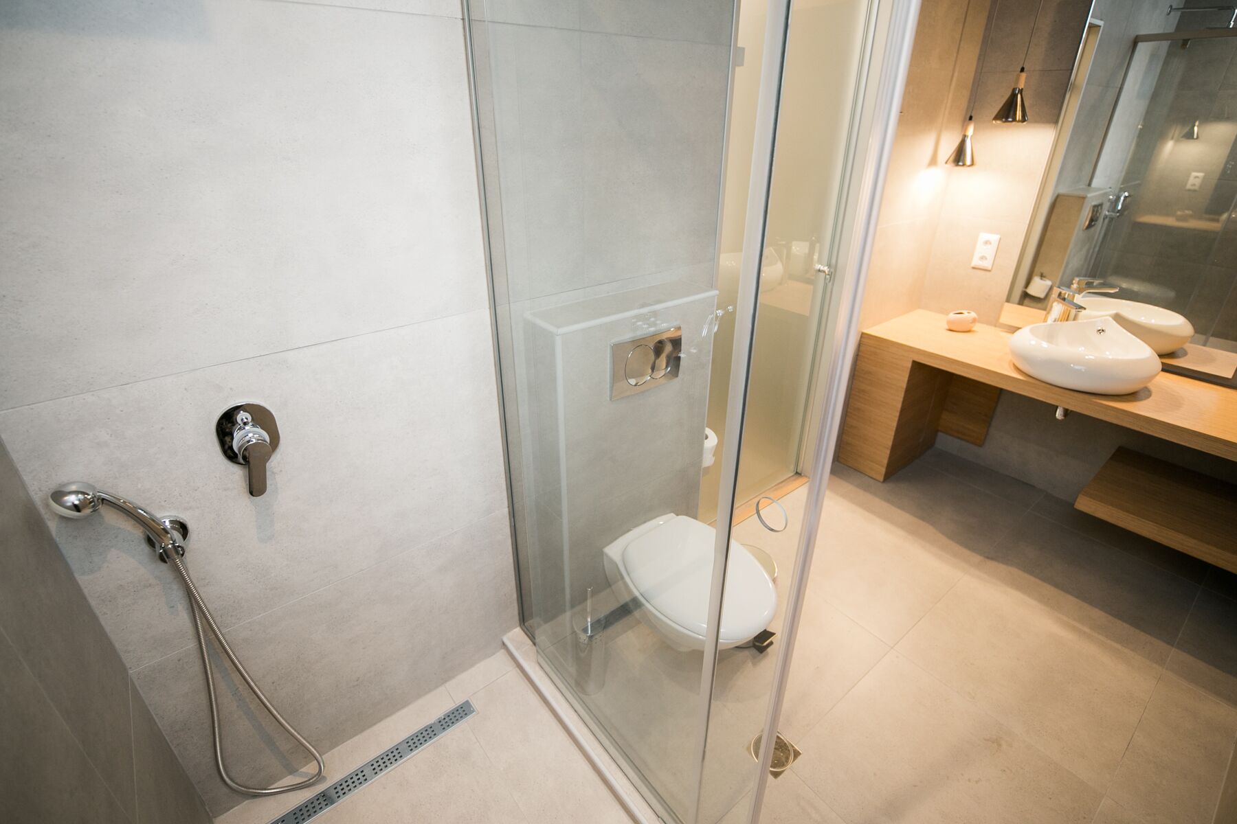 Une salle de bain moderne avec une douche à parois de verre, des toilettes et un lavabo avec un miroir.