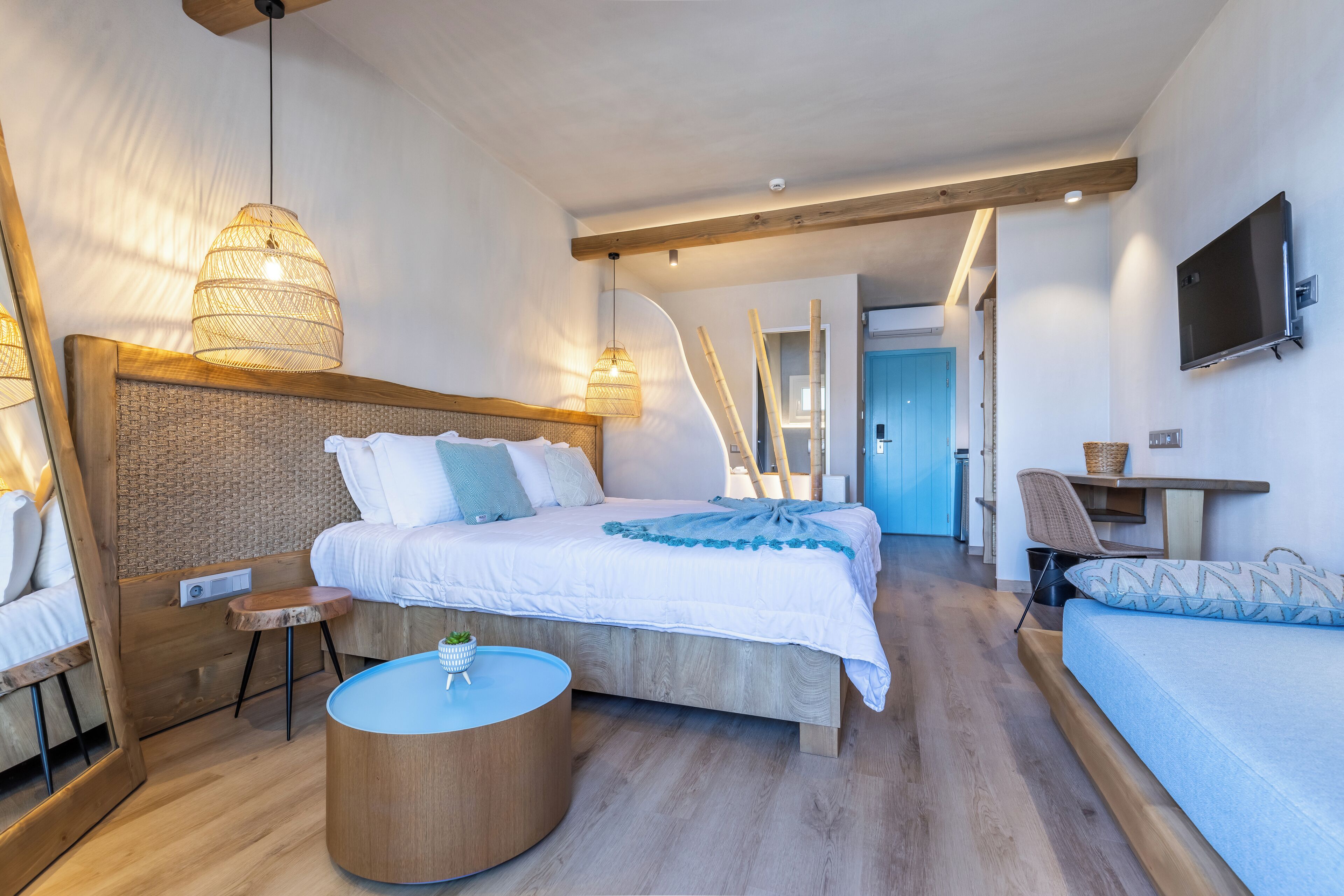 A modern bedroom with a large bed, bedside tables, a TV, and a desk.