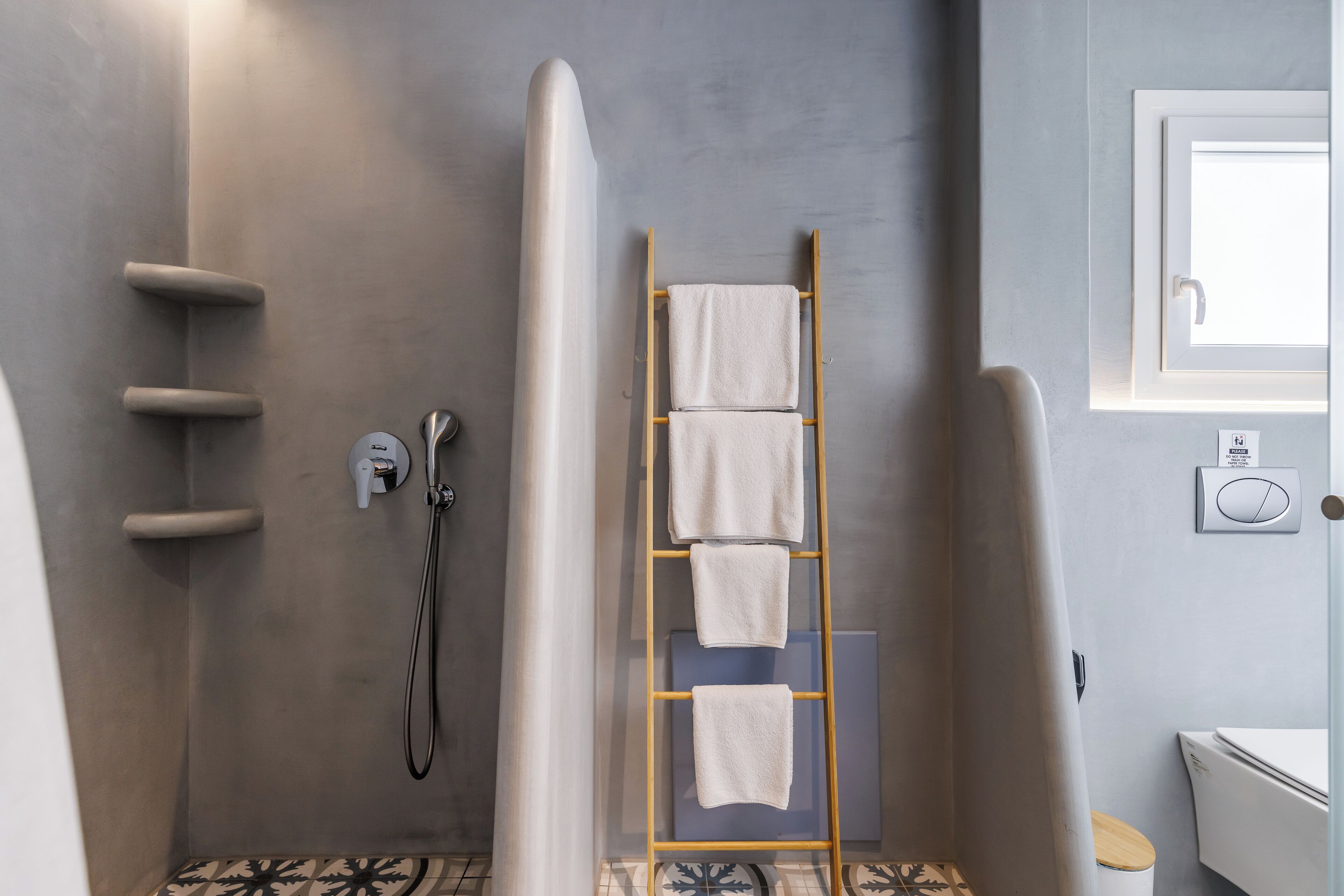 A modern bathroom with a shower, a towel rack, and a toilet.
