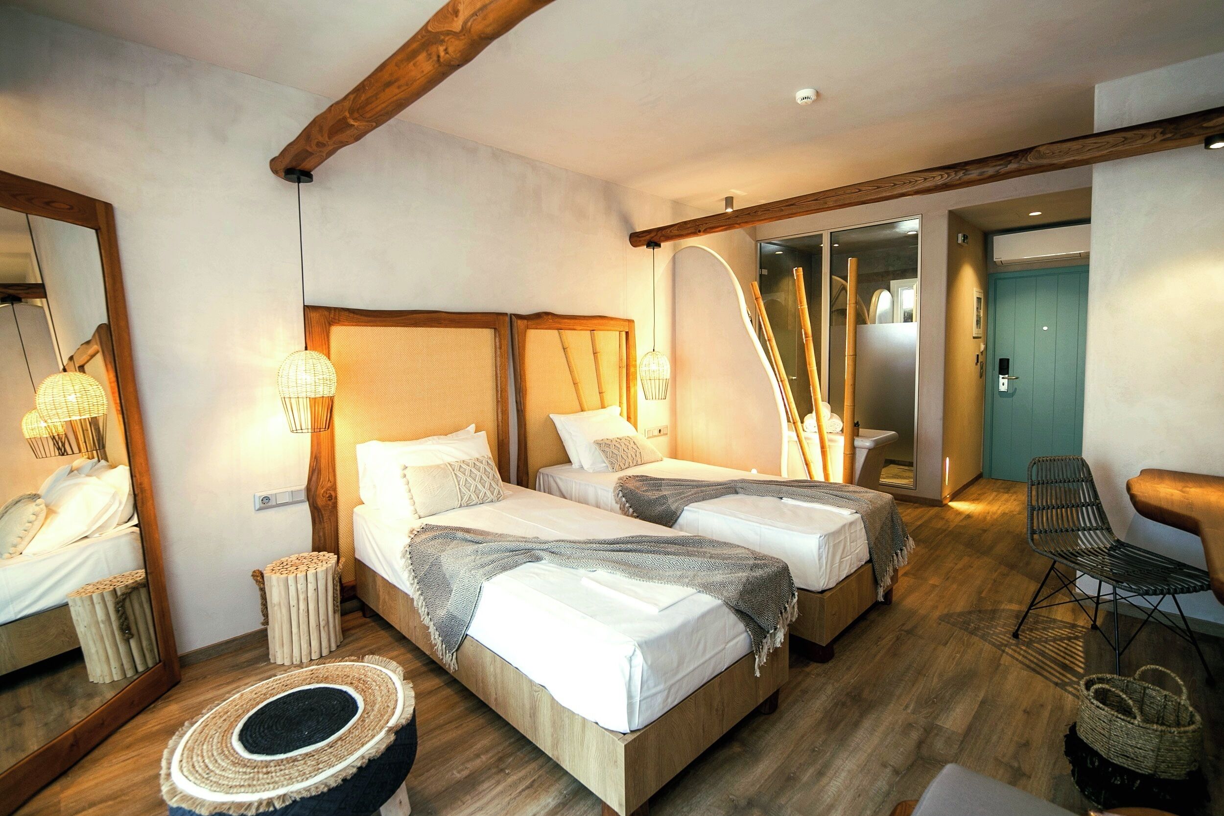 Une chambre d’hôtel avec deux lits, un grand miroir et un plafond en bois.