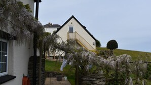 A white house with a stone wall and a wooden fence.