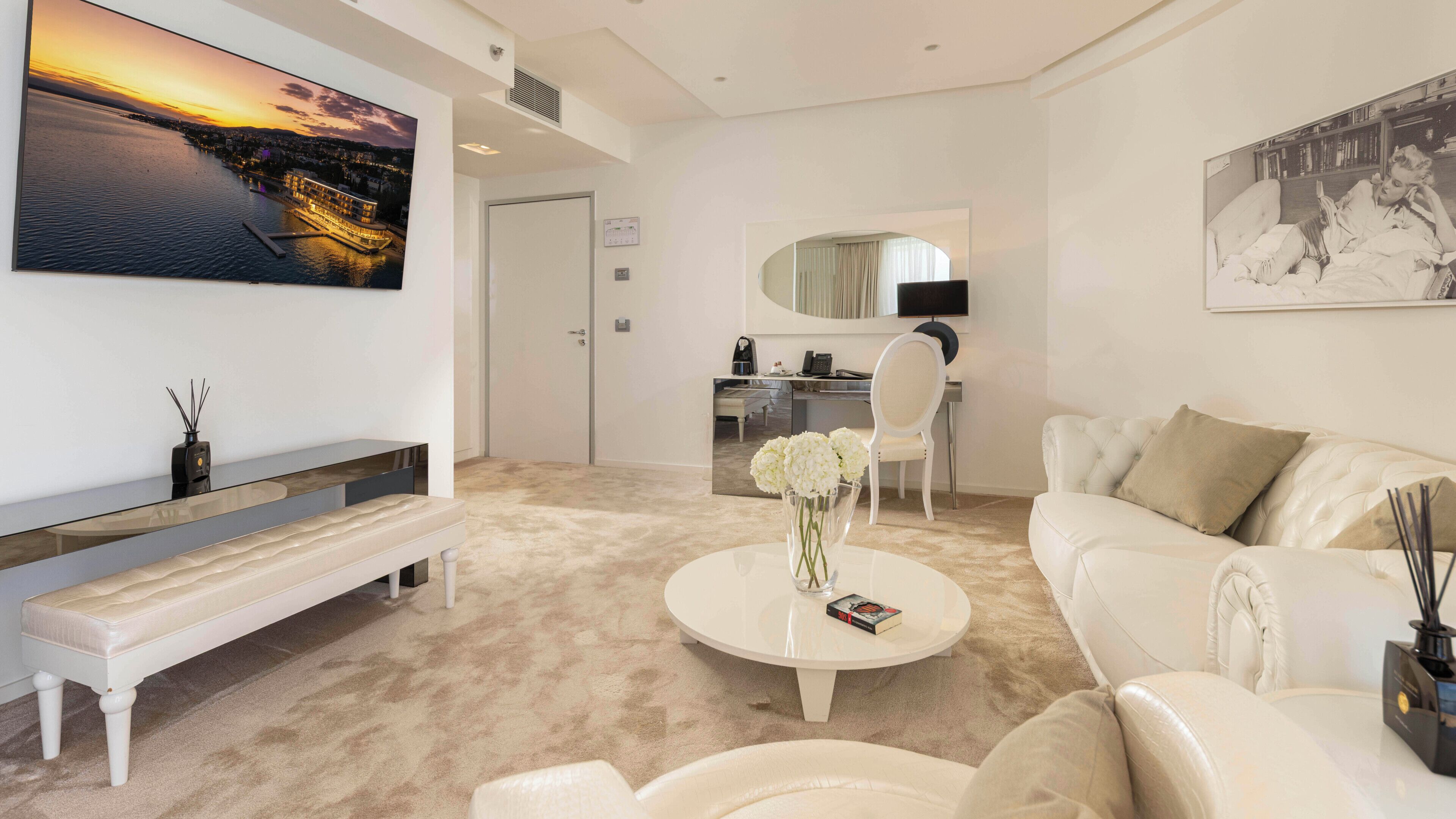 Ein modernes Wohnzimmer mit einem großen Gemälde, einem Sofa, einem Couchtisch und einer Bank.