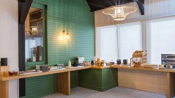 A kitchen with a green wall, wooden counter, and various food items.