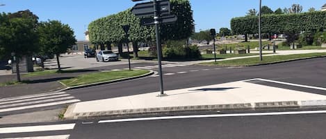 Una intersección de calles con un cartel de indicaciones, un paso de peatones y un cielo azul despejado.