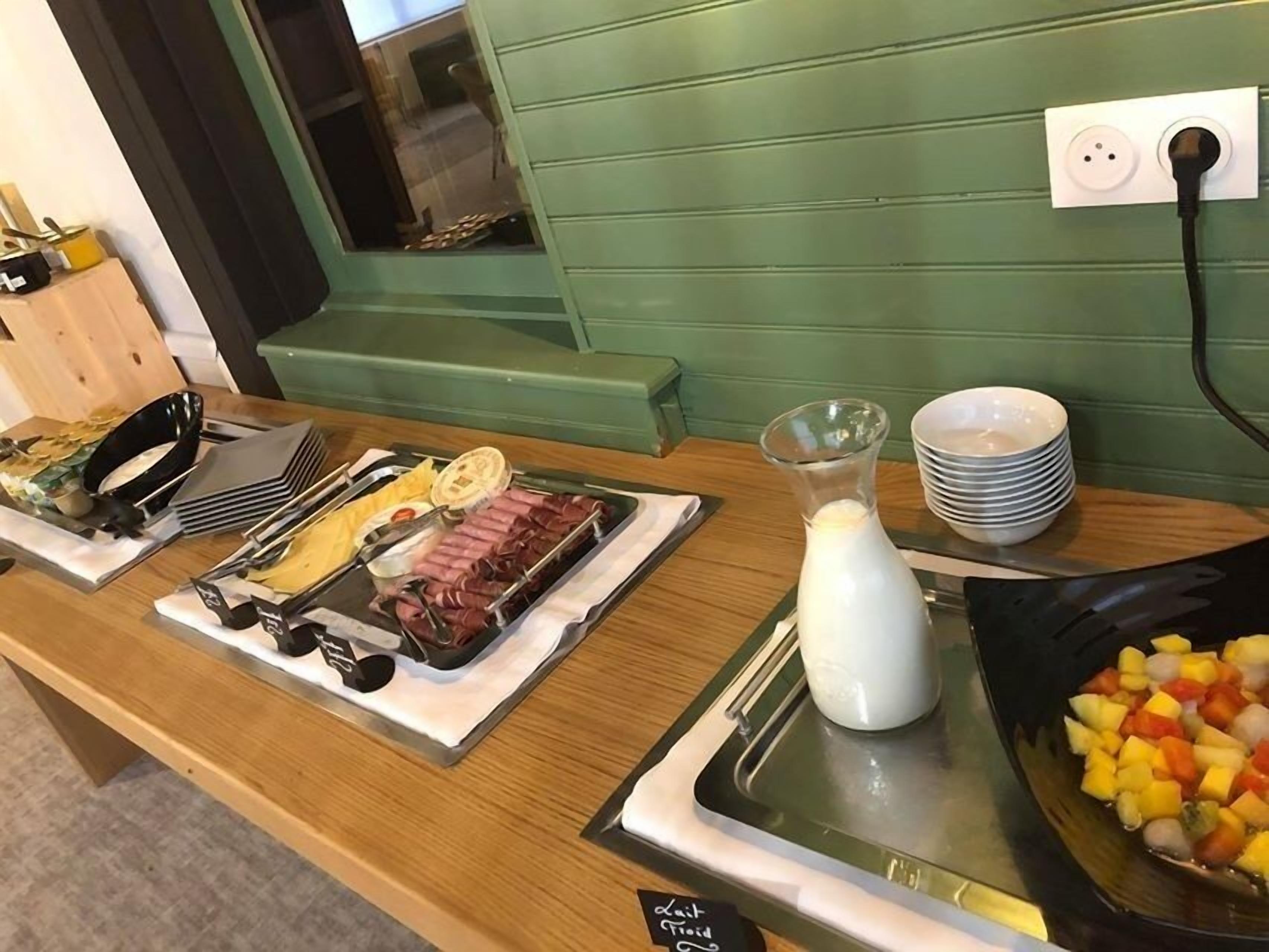 En morgenmadsbuffet med et udvalg af retter og en kande mælk.