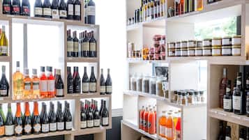 Viini- ja väkevien alkoholijuomien myymälä, jossa on useita hyllyjä täynnä pulloja ja purkkeja.
