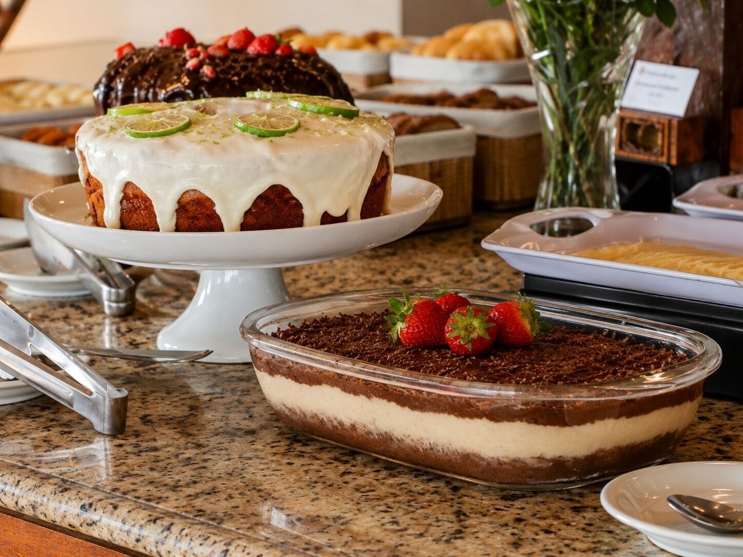 A dessert buffet with various cakes and a layered chocolate dessert.