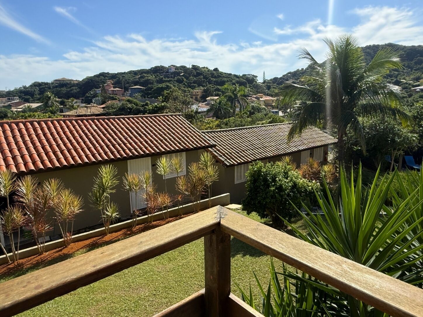 Un barrio residencial con casas, una valla de madera y una colina al fondo.