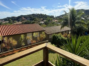 A residential area with houses, a wooden fence, and a hill in the background. - Calador Búzios Hotel (Búzios)
