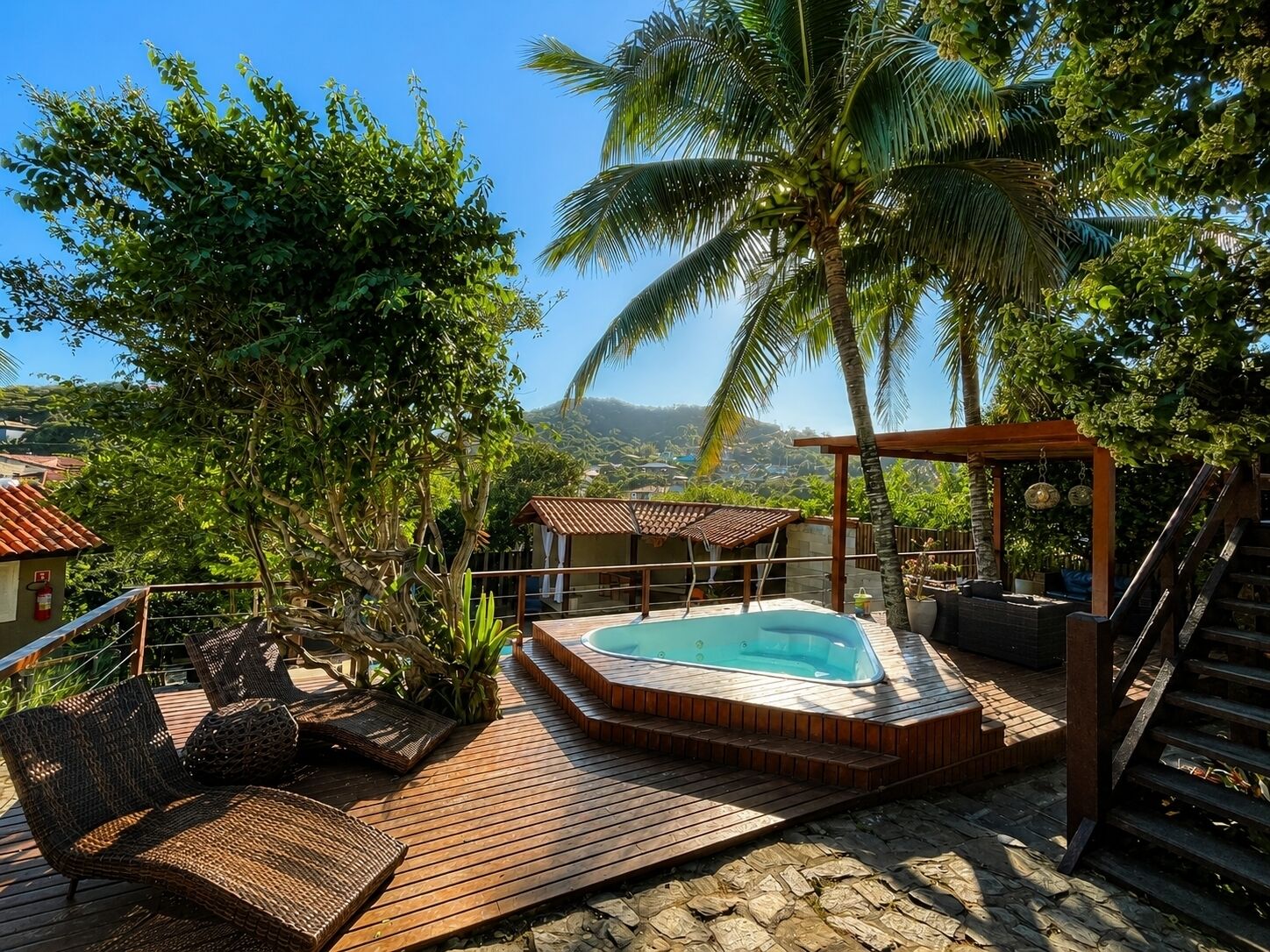 A wooden deck with a hot tub, lounge chairs, and a pergola with hanging decorations.