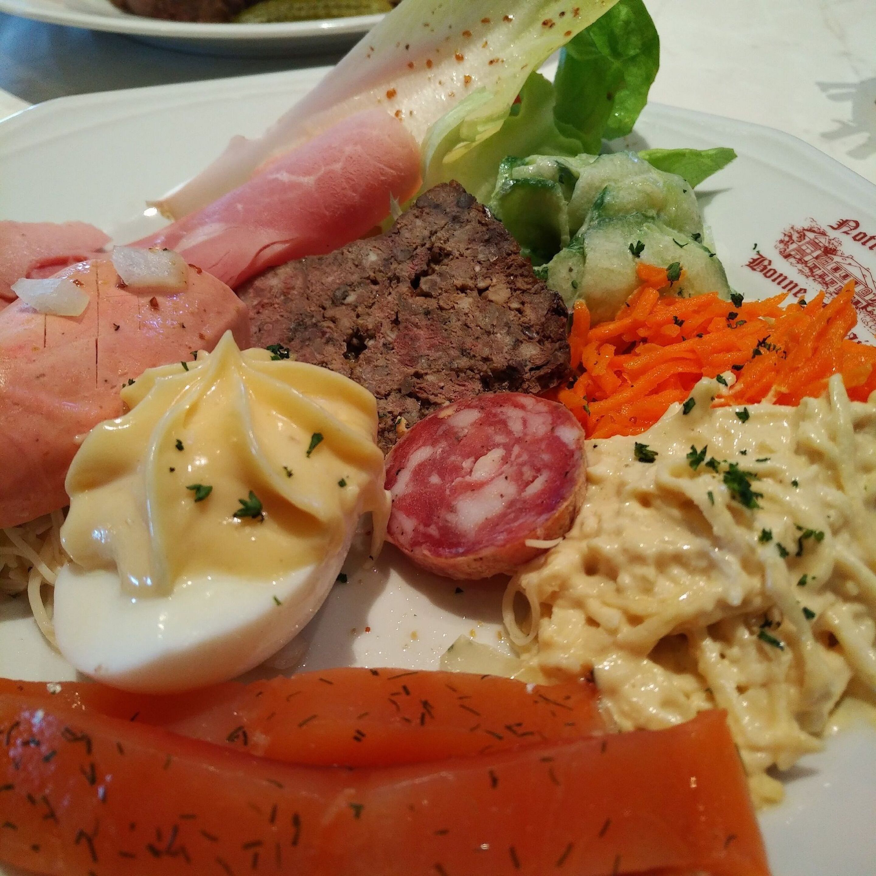 A plate with various foods including eggs, meat, and vegetables.