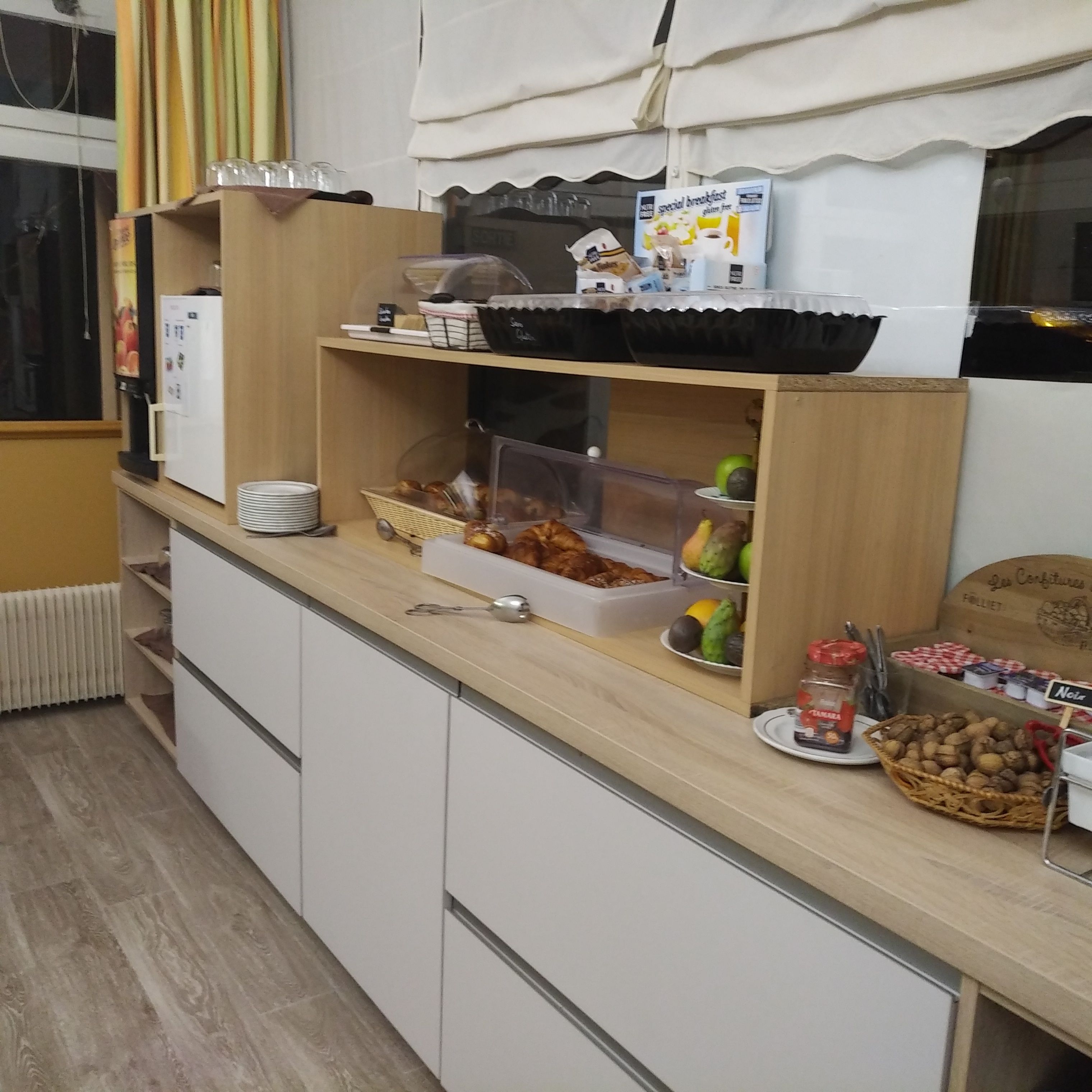 Una barra de desayuno con diversos alimentos y una máquina de café.