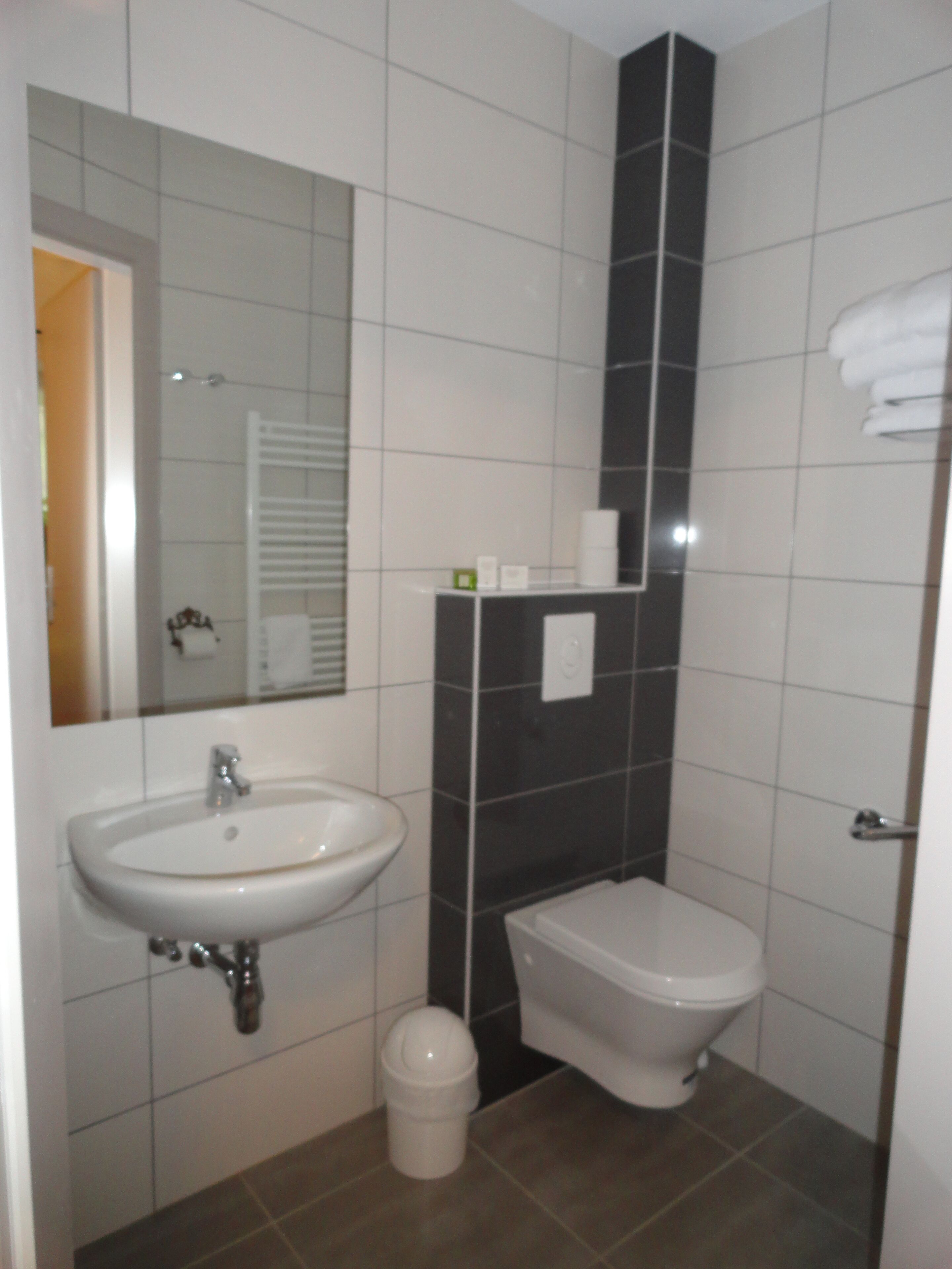 A bathroom with a sink, toilet, and bidet.