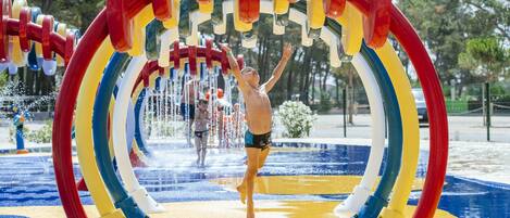 Ein Wasserpark mit Wasserrutsche und einer Person, die im Wasser spielt.