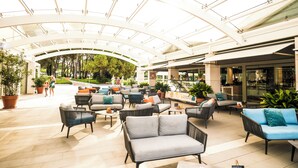 A spacious outdoor seating area with modern furniture and a glass ceiling, providing a view of the surrounding greenery. - Zaton Holiday Resort Apartments (Nin)
