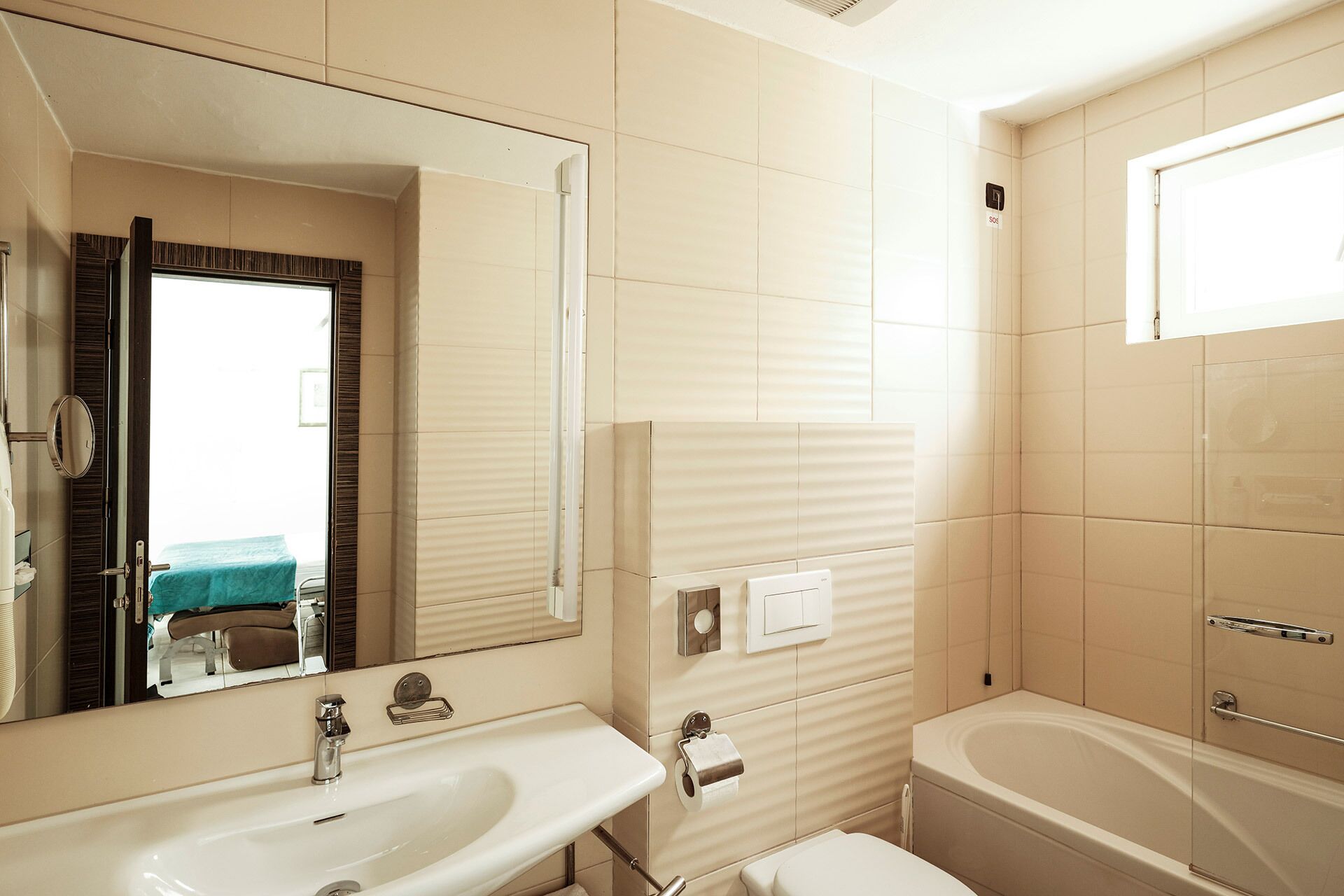 Une salle de bain équipée d’un lavabo, d’un miroir, de toilettes et d’une baignoire.