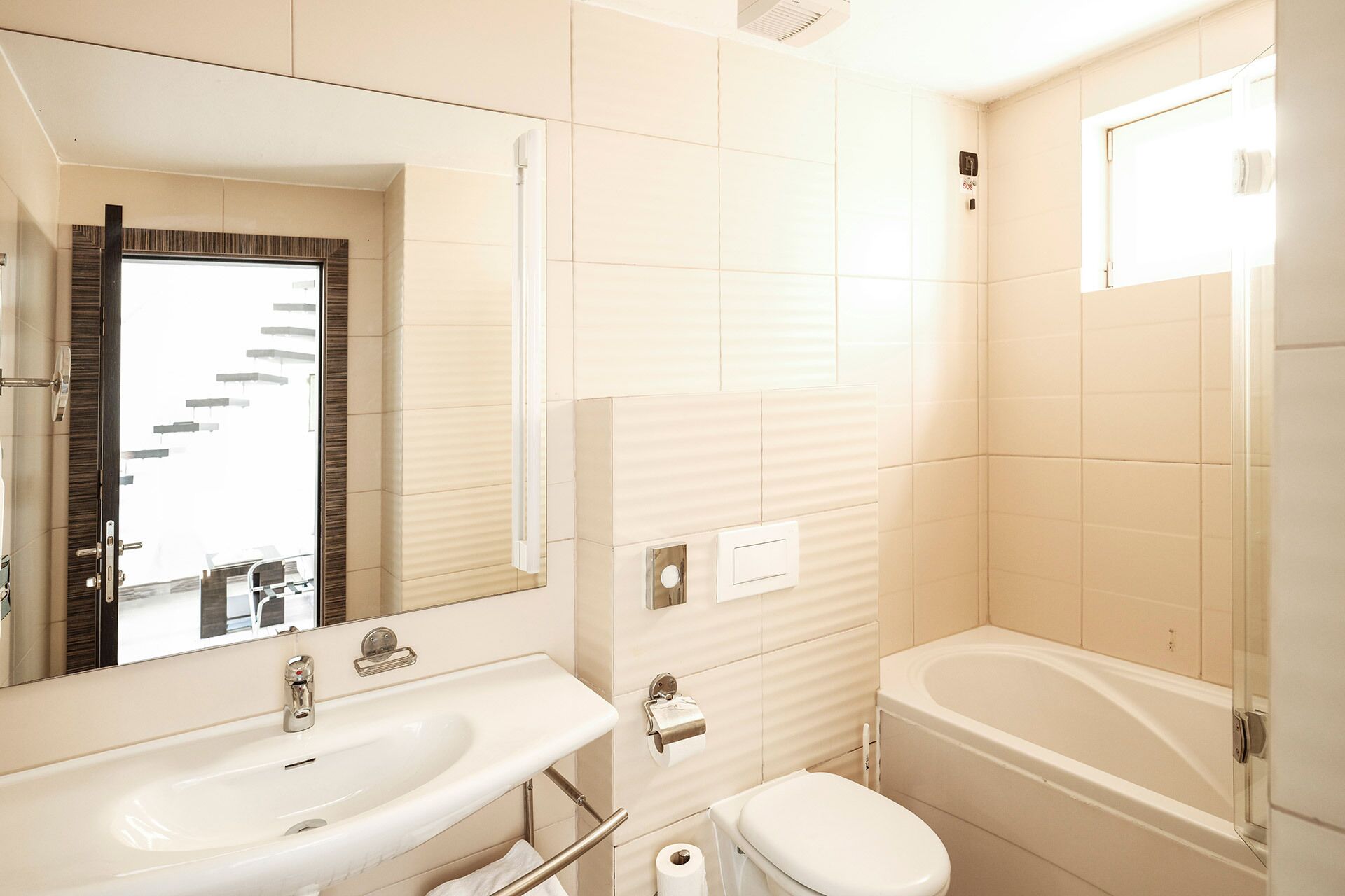 A bathroom with a sink, mirror, toilet, and bathtub.