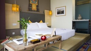A hotel room with a bed, bedside table, and a wall with a decorative tapestry. - City Inn Happy Valley Chengdu (Chengdu)