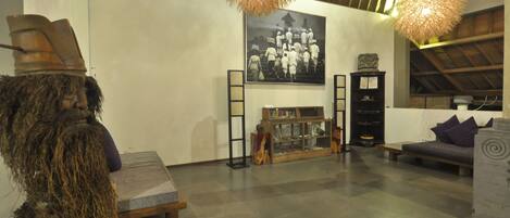 A spacious room with a high ceiling, a fireplace, and a large framed photograph on the wall.
