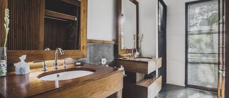 A modern bathroom with a wooden vanity, two sinks, and a large mirror.