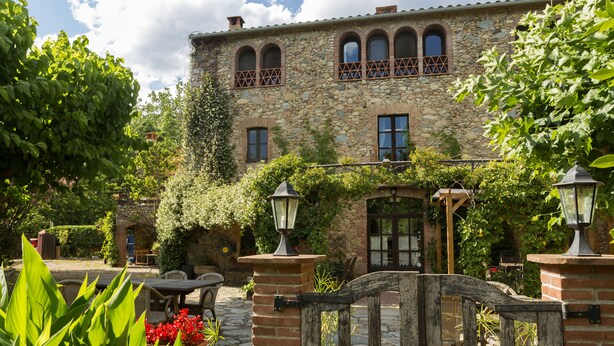 Un edificio de piedra con ventanas de arco y una puerta de madera.