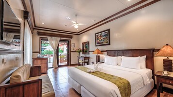 Habitación de hotel con una cama grande, un escritorio, una silla, una lámpara y un cuadro en la pared.