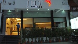 A hotel entrance with a sign reading "JHT Hotels" and a red flame logo. - Jht Hotels (New Delhi)