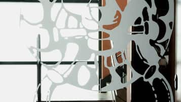 A modern interior with a decorative metal partition featuring abstract designs.
