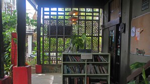 A book exchange area with a green bookshelf filled with books, a sign indicating it's for reading pleasure, and a wooden fence in the background. - The Lazy Dog Bed & Breakfast (Boracay Island)