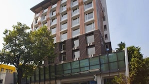 A multi-story building with a modern architectural design, featuring a combination of brick and glass facades. - The HQ (Vasco da Gama)