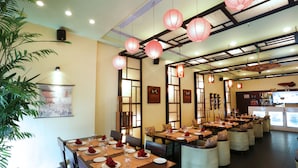 A restaurant with multiple dining tables, chairs, and red lanterns hanging from the ceiling. - The HQ (Vasco da Gama)