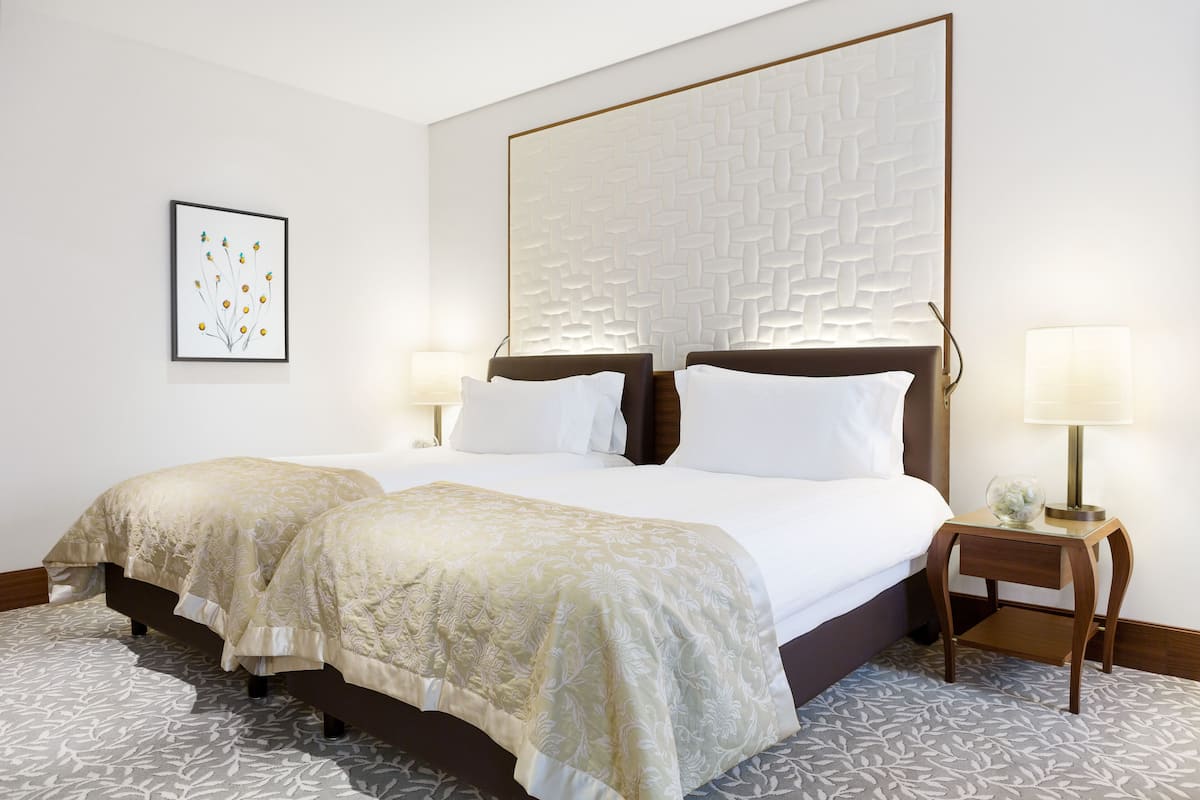 A double bed with a headboard, two bedside tables, and a framed artwork on the wall.