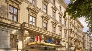 A historic building with ornate architectural details, a prominent entrance, and flags. - The Ritz-Carlton, Vienna (Vienna)