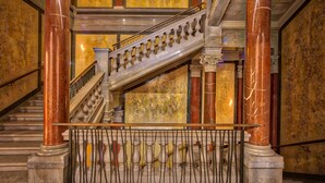 A grand staircase with ornate balustrades, marble columns, and a decorative railing. - The Ritz-Carlton, Vienna (Vienna)
