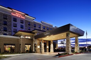 A hotel with a stone facade, a covered entrance, and a clear sky. - Hilton Garden Inn Texarkana (Texarkana)