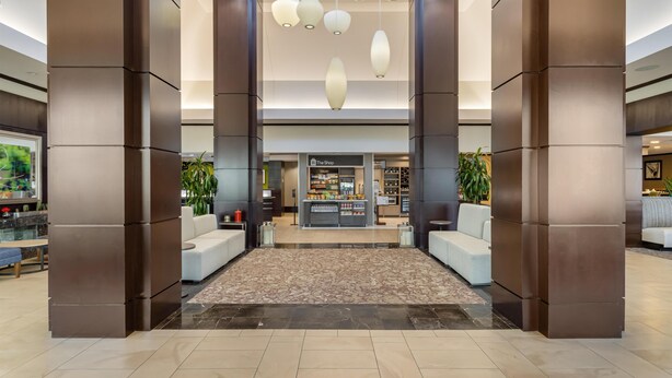 Un hall d’entrée avec un comptoir de réception, un espace salon et une boutique appelée « The Shop ».