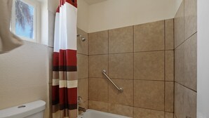 A bathroom with a shower, toilet, and bathtub. - Red Roof Inn Needles (Needles)