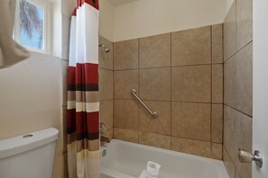 A bathroom with a shower, toilet, and bathtub. - Red Roof Inn Needles (Needles)