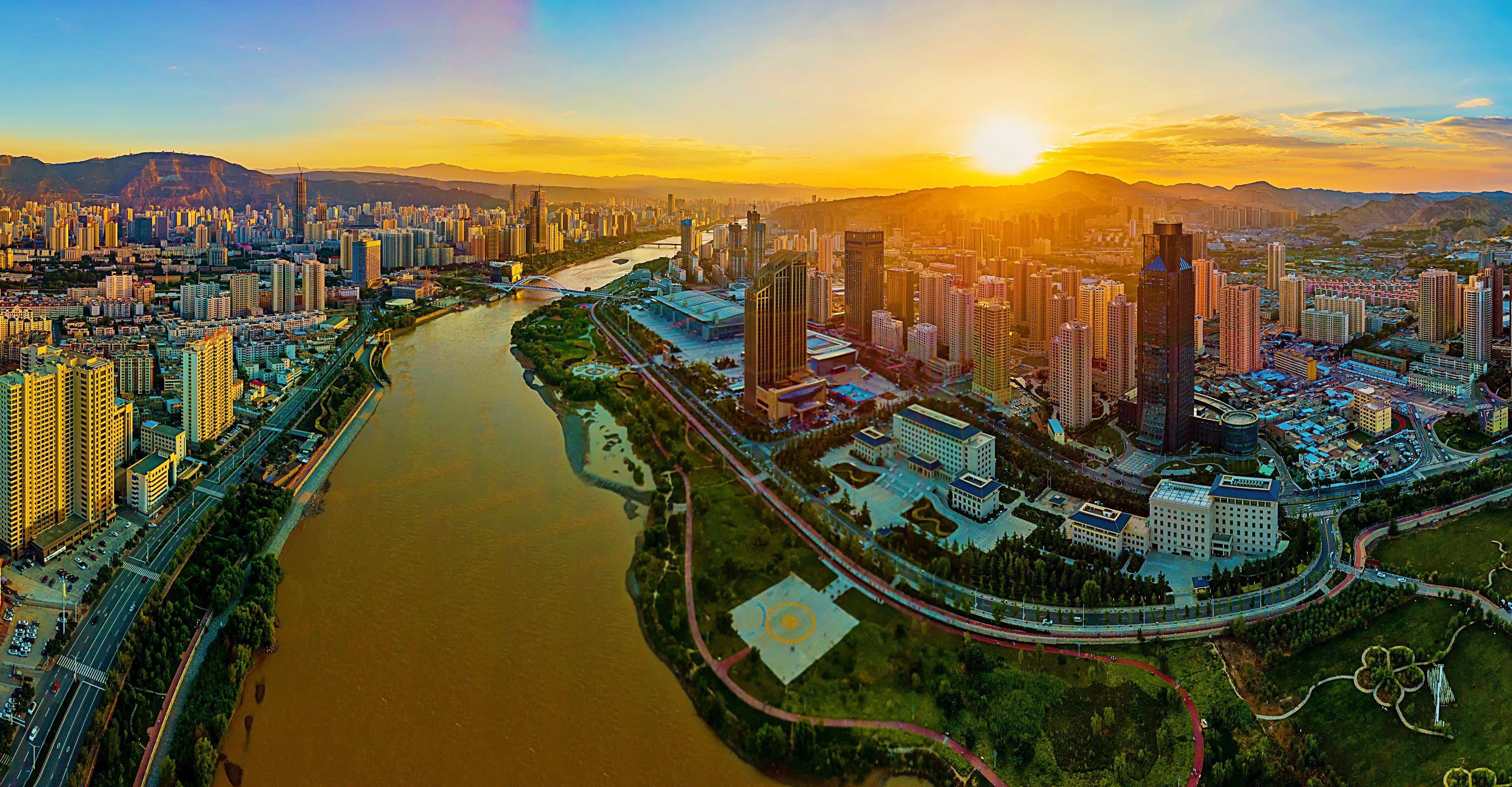 A cityscape with a river, high-rise buildings, and a bridge.