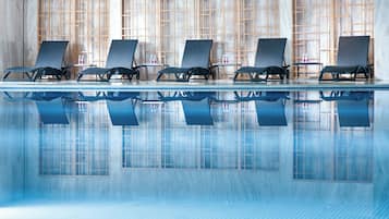A poolside area with lounge chairs and a tiled floor.