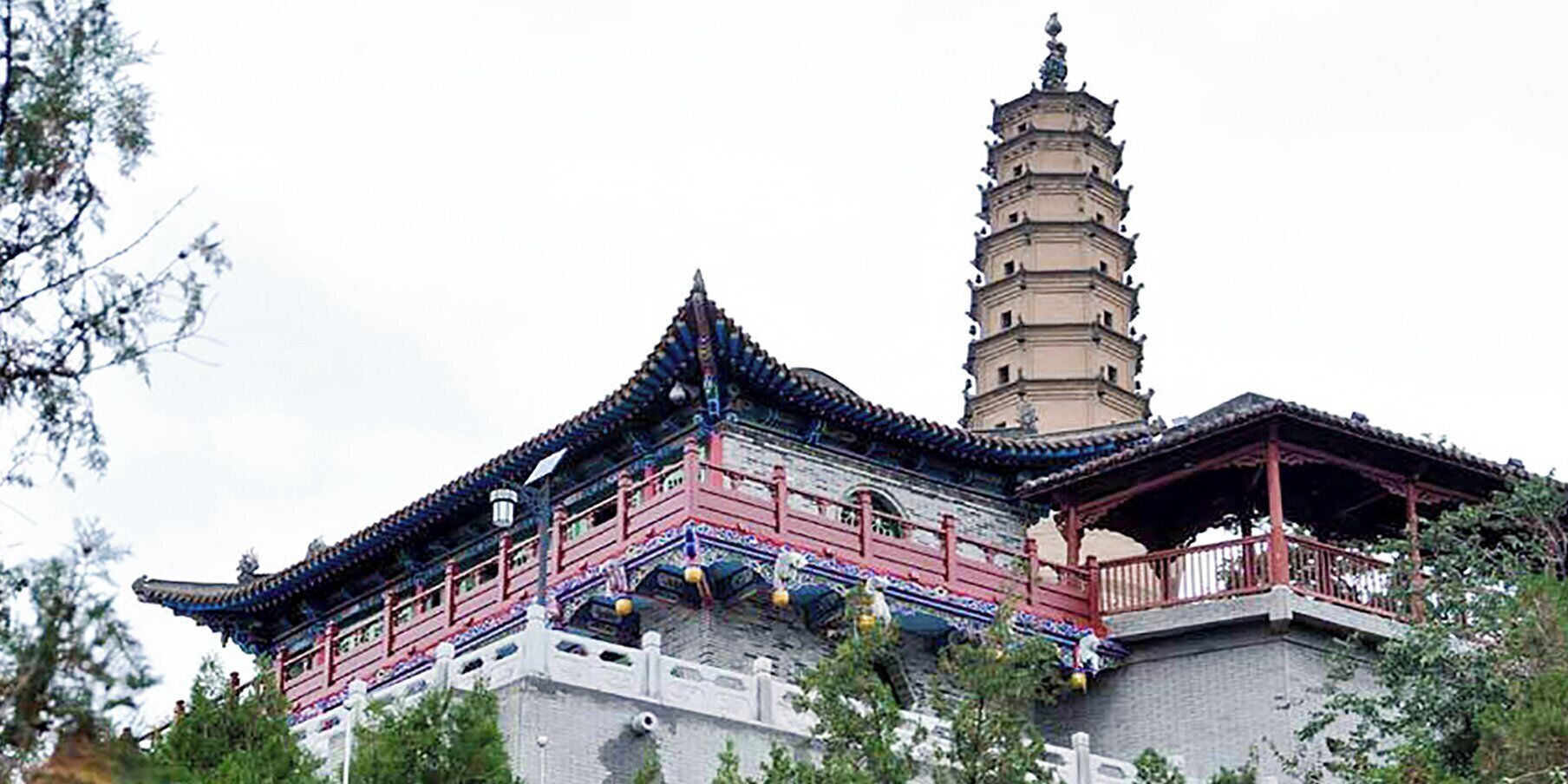 Un edificio tradicional de estilo pagoda con una torre de varios niveles y un pabellón de techo rojo.