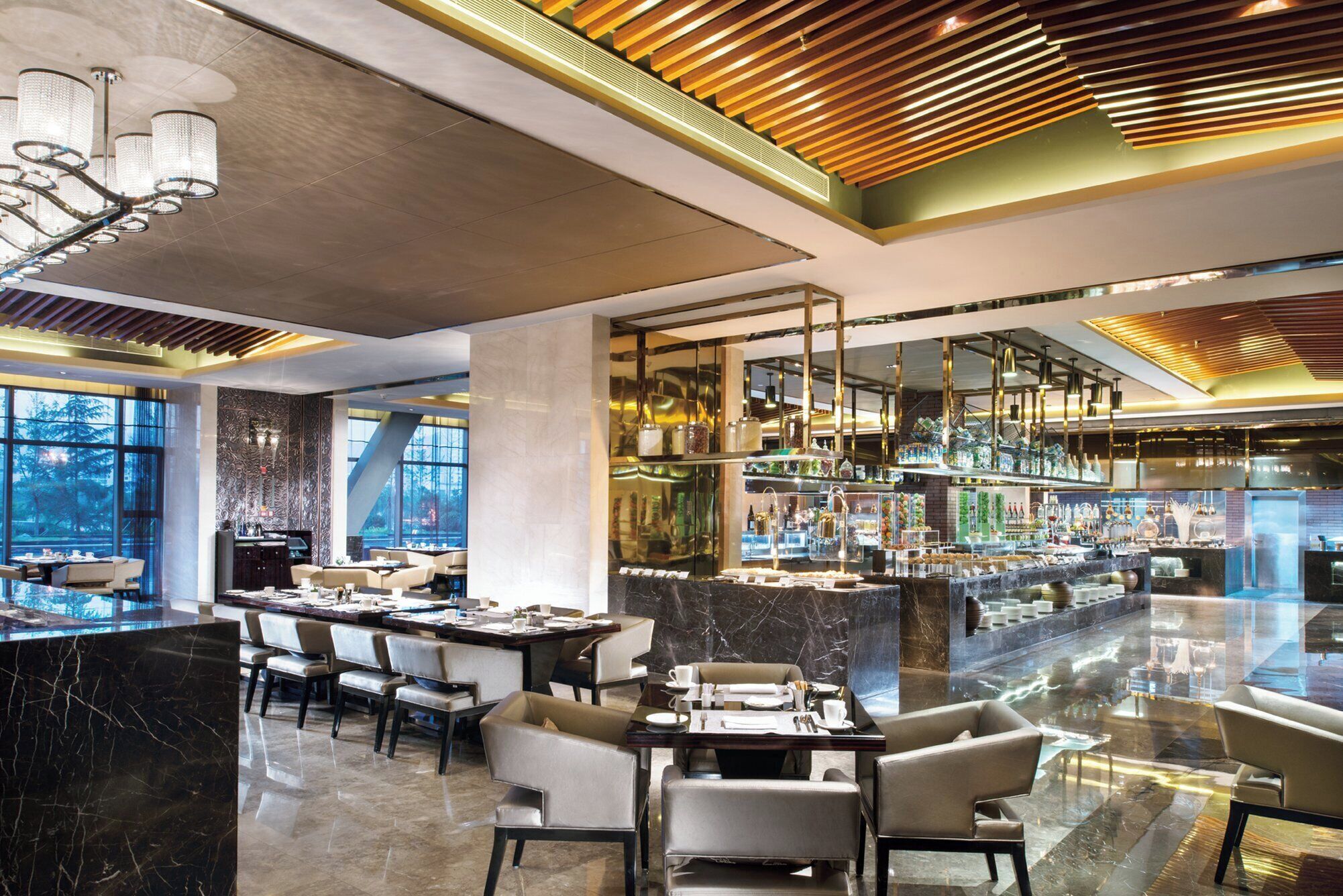 Un hall d’hôtel moderne avec un sol en marbre, un bar doté de vitrines et un espace détente avec des tables et des chaises.