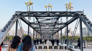 A pedestrian bridge with a metal framework and yellow decorative elements.